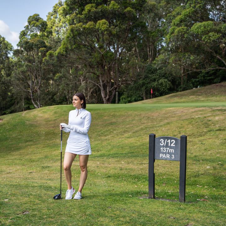 Female golfer in white outfit 